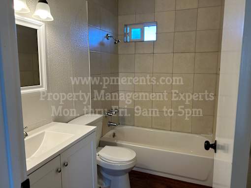 A white bathroom with a toilet, sink, and bathtub.