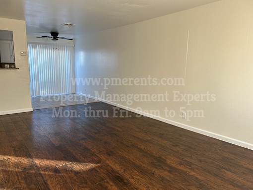A room with a wooden floor and a ceiling fan.