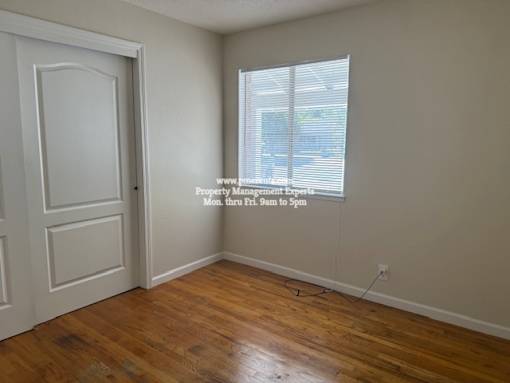 A room with a door and a window with blinds.