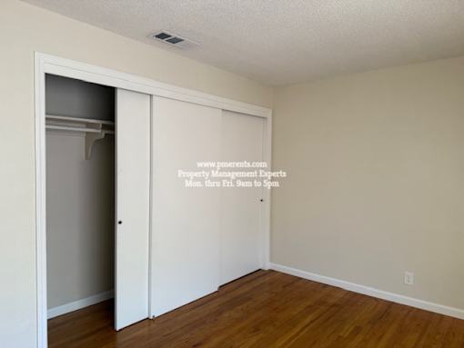 A room with a white door and a white wall with a website address on it.