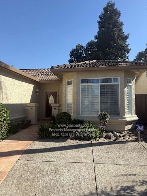 A house with a driveway and a sign in front.