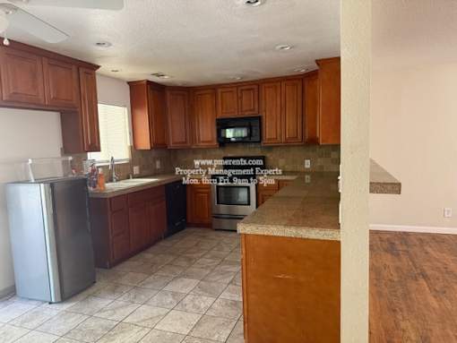 A kitchen with wooden cabinets and a tile floor.