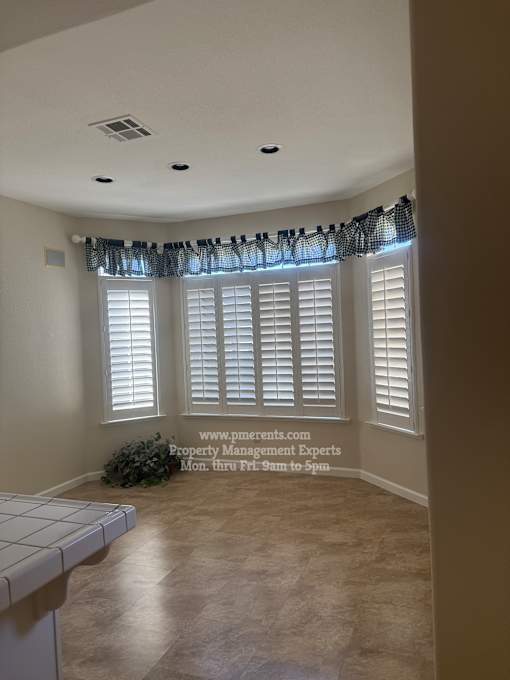 A room with a window covered by a black curtain.