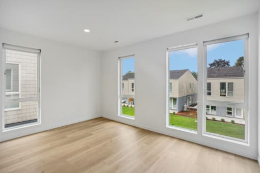 a living room with large windows and a wooden floor