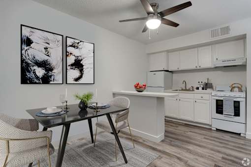 A modern kitchen with a dining table and chairs.