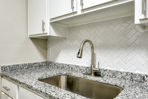 a kitchen with white cabinets and a sink