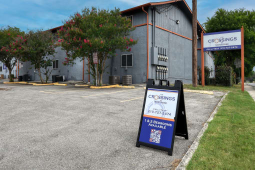 a sign in front of a building advertising car rentals at The Crossings at Montrose Apartments, San Antonio