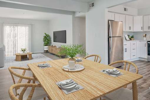 A dining table set with plates and a potted plant on top.