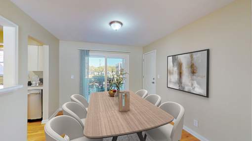 A dining room with a table and chairs.