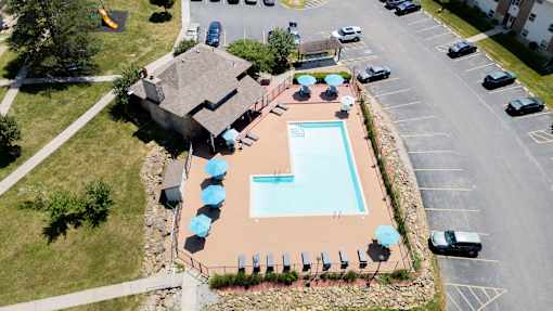 An aerial view of a pool surrounded by a parking lot.