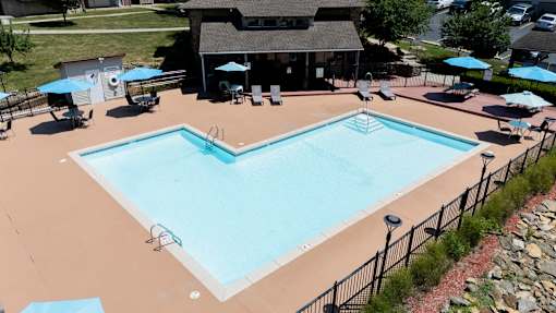 A large outdoor swimming pool surrounded by a black fence.