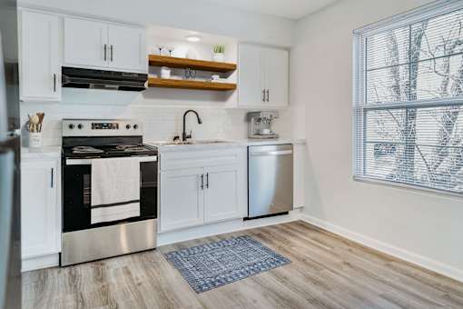 A modern kitchen with a stainless steel oven and white cabinets.