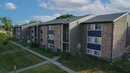 Apartment complex with a grassy area in front.