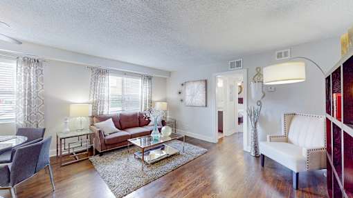 A living room with a red couch and a white chair.