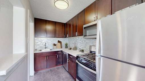 A kitchen with a white refrigerator and wooden cabinets.