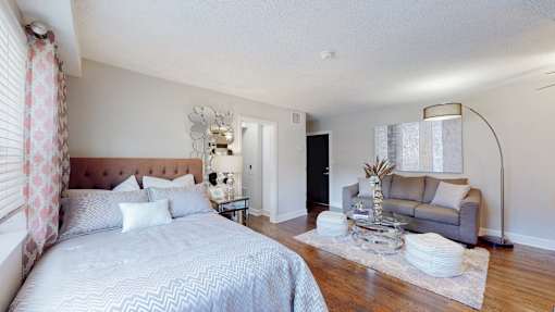 A bedroom with a large bed and a couch.