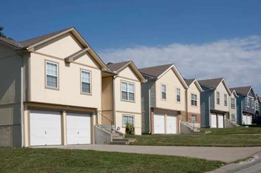 a row of houses with garages and a sidewalk