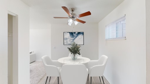 a dining room with a table and chairs and a ceiling fan