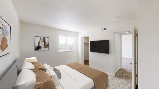 a bedroom with a bed and a tv on the wall