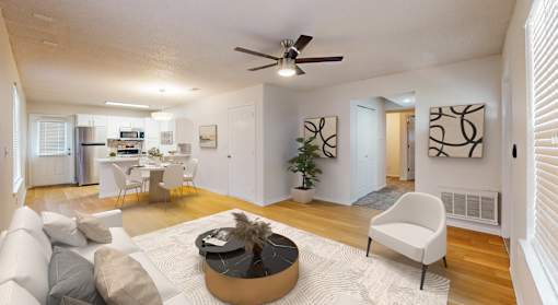 A living room with a white couch, a coffee table, and a ceiling fan.