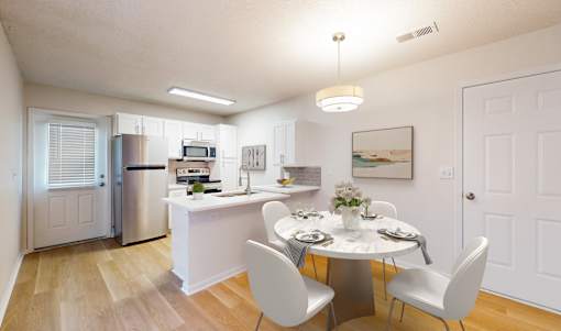 A kitchen with a dining table and chairs.