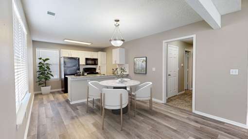 A kitchen with a dining table and chairs.