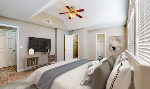 A bedroom with a large bed and a ceiling fan.
