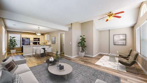 A living room with a grey couch, a coffee table, and a ceiling fan.
