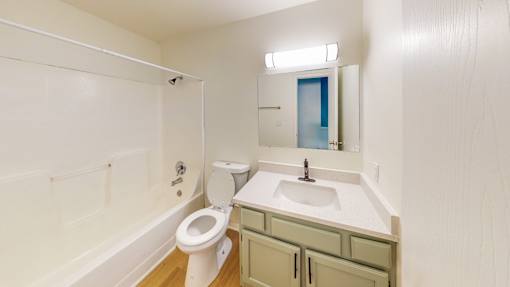 a bathroom with a toilet sink and tub and a mirror