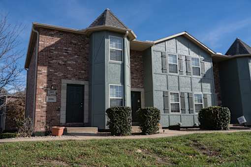 A house with a brick facade and a grey extension.