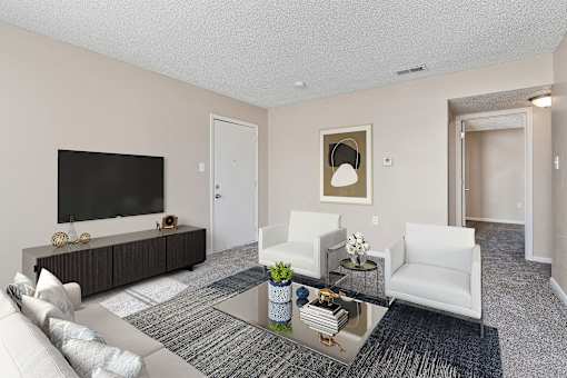 A living room with a white couch, a black television, and a coffee table.