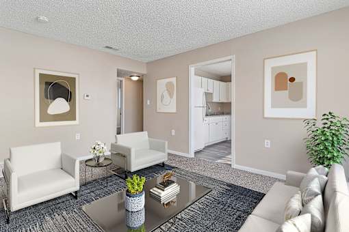 A living room with a white couch, a coffee table, and a potted plant.