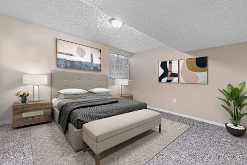 A bedroom with a large bed and a potted plant.