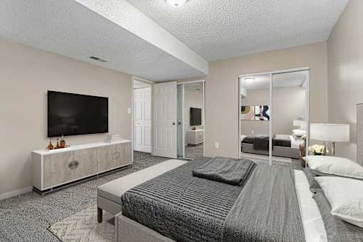 A bedroom with a large bed and a television on a cabinet.