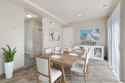A dining room with a wooden table set for two.