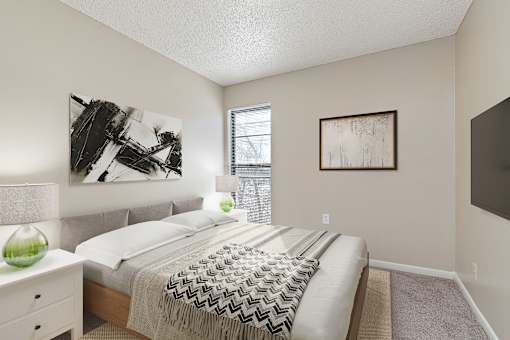 A bedroom with a bed, nightstand, and two pictures on the wall.