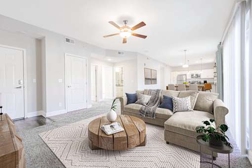 A living room with a couch, coffee table, and a ceiling fan.