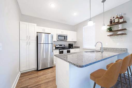 A kitchen with a granite countertop and a refrigerator.