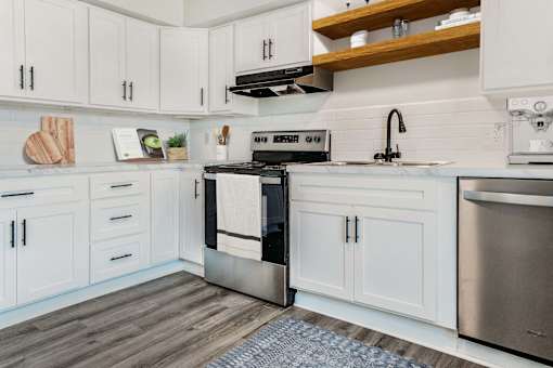 A modern kitchen with white cabinets and stainless steel appliances.