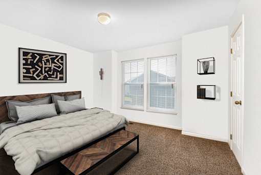 A bedroom with a large bed and a picture on the wall.