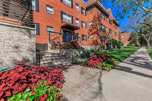 A red brick building with a green lawn in front.