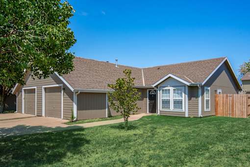 A house with a brown roof and a grey garage door.