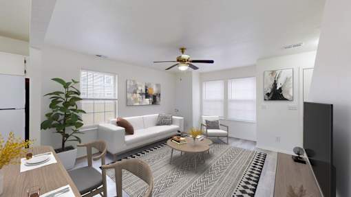 A living room with a white couch, a coffee table, and a ceiling fan.