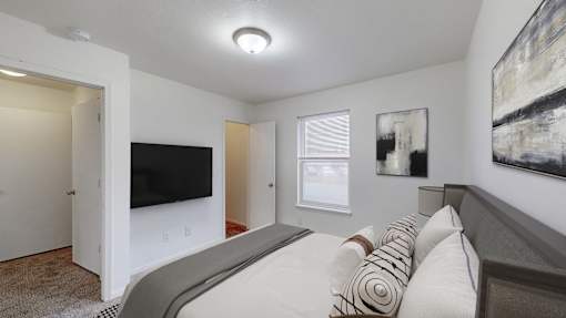 A bedroom with a large bed and a flat screen TV.