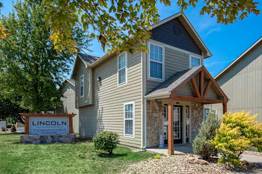 A house with a sign that says Lincoln Townhomes in front of it.