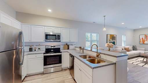 A modern kitchen with stainless steel appliances and white cabinets.