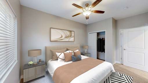 A bedroom with a bed, a ceiling fan, and a painting on the wall.