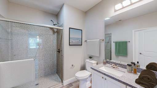 A bathroom with a white toilet, sink, and shower.
