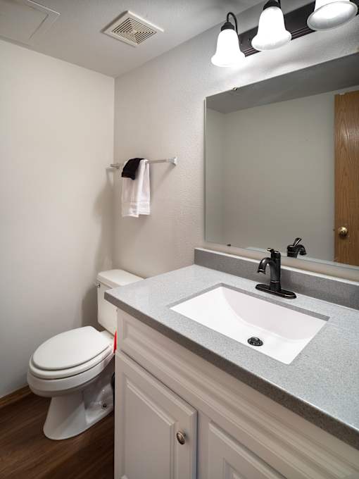 A white toilet sits next to a sink in a bathroom.