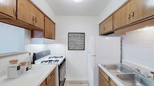 A kitchen with a white fridge and wooden cabinets.